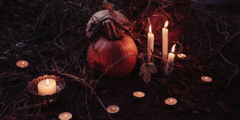 candles and a pumpkin on the ground