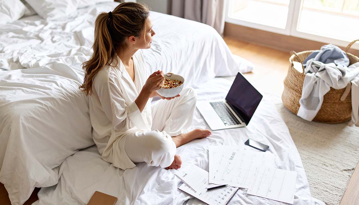 cereal - Low Two Pair A person casually eating cereal in their pajamas, mid-morning, surrounded by chaos—laundry on the floor, a laptop open to unread emails, a calendar with scribbled-over appointments. They sit peacefully, spoon mid-air, staring out the window—totally unfazed.