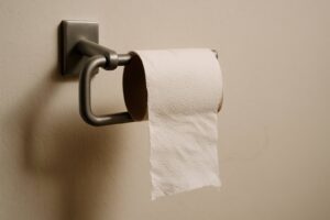 A nearly empty toilet paper roll hanging by a thread, symbolizing life's small disappointments.