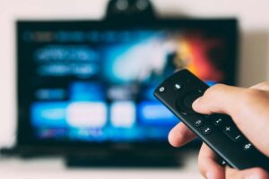 a tv remote and a person trying to choose what to watch