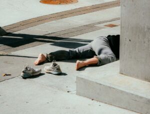a person laying facedown on the concrete with shoes off