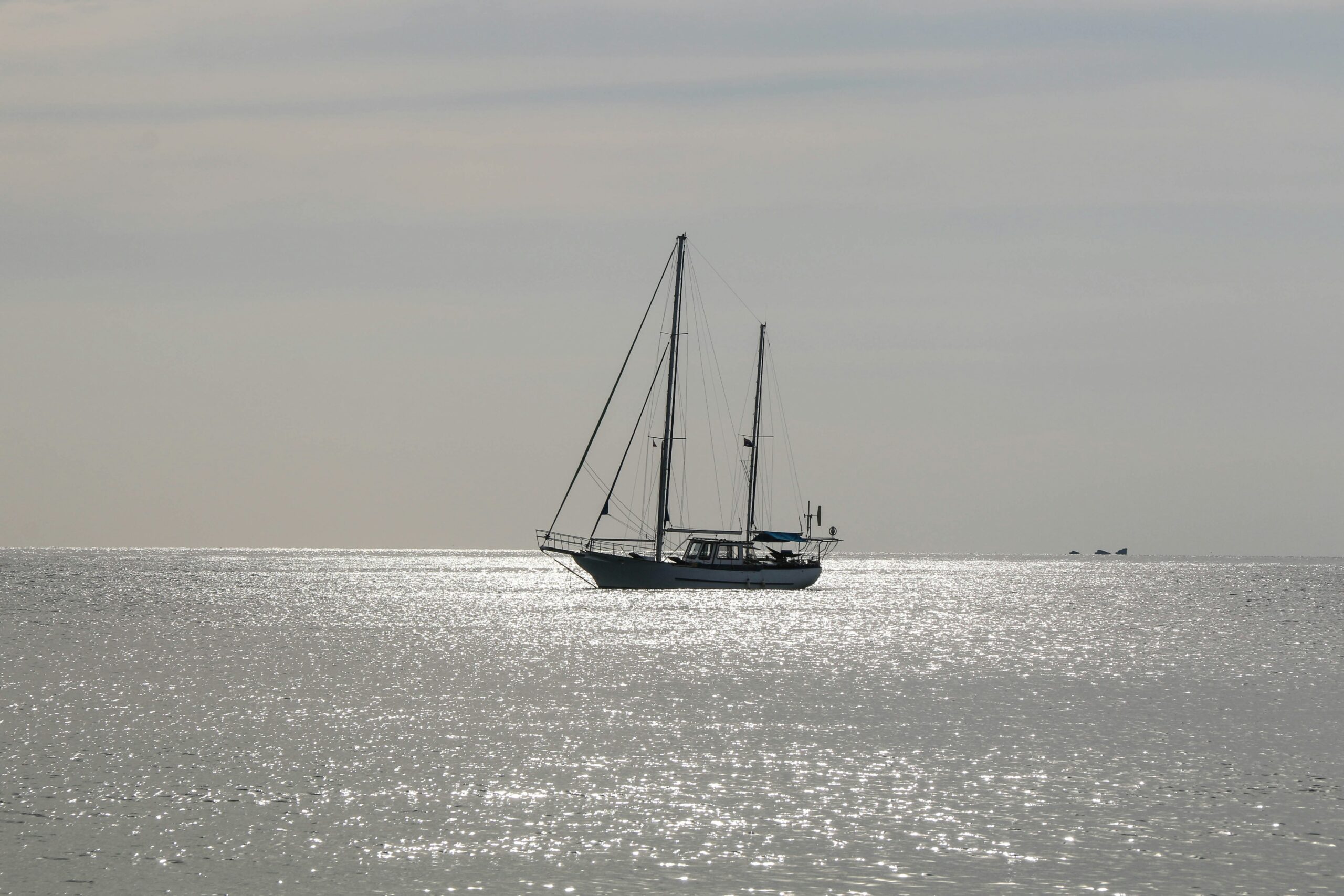 natalia-slastnikova-ogj41NpndZ4-unsplash - Low Two Pair A lone boat floats in the middle of the ocean, symbolizing isolation and perspective from the water.