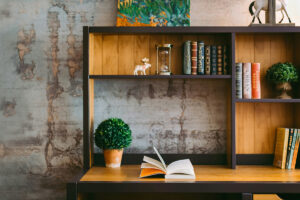 a bookshelf with a table and an open book in the foreground