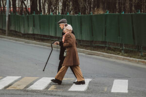 two elderly people walking down the street