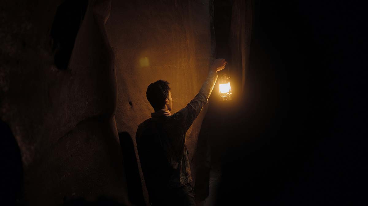 lantern-night - Low Two Pair a man in a cave holding a lantern