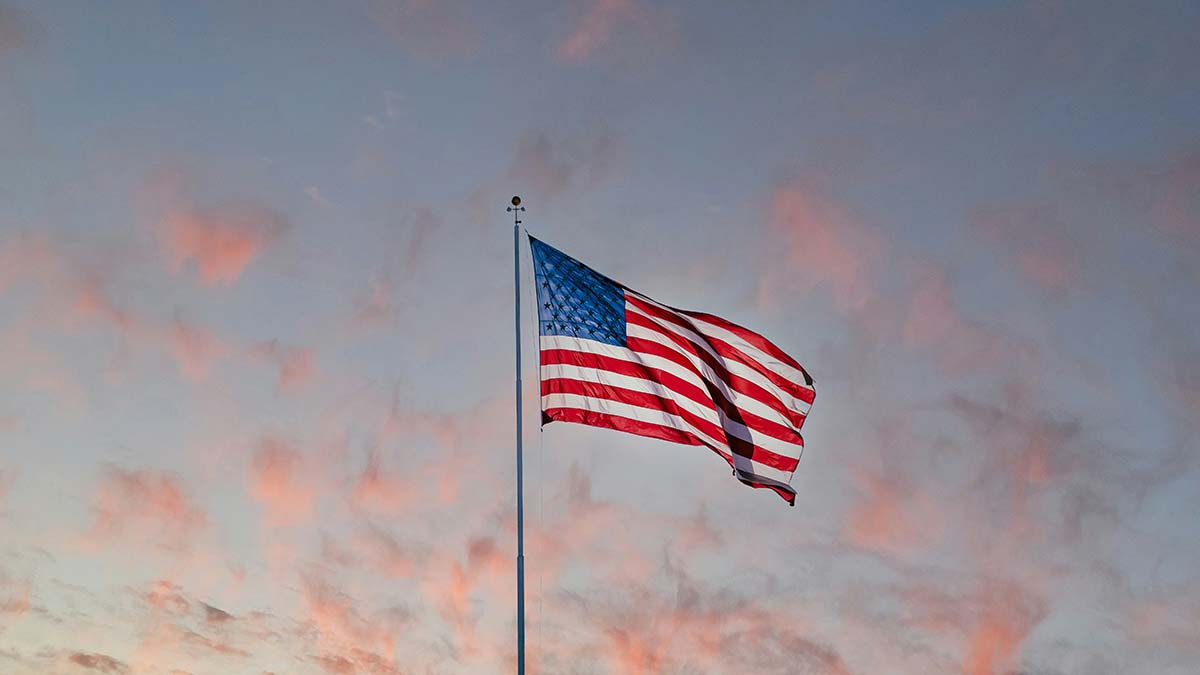 An American flag waving in morning light, symbolizing remembrance, gratitude, and hope on Veterans Day.”